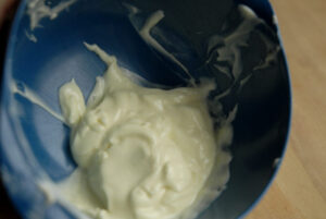 Blå skål med vegansk smør der ligner mayonnaise fordi det ikke er størknet endnu