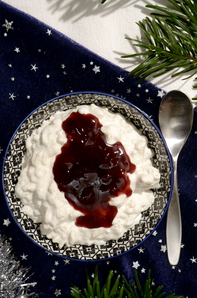 Glasskål med vegansk risalamande og kirsebærsovs. På en hvid og blå juledug.