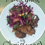 På en grøn baggrund står en lyseblå tallerken anrettet med en smuk salat i mange farver og en portion Vegansk and også kendt som mock duck. Henover billedet står der skrevet Mock duck a la Chris parentes mas